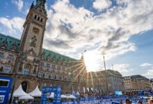 Spectacular cityscape during a triathlon event with historic architecture, race infrastructure, and athletes, capturing the vibrant atmosphere of a triathlon competition.