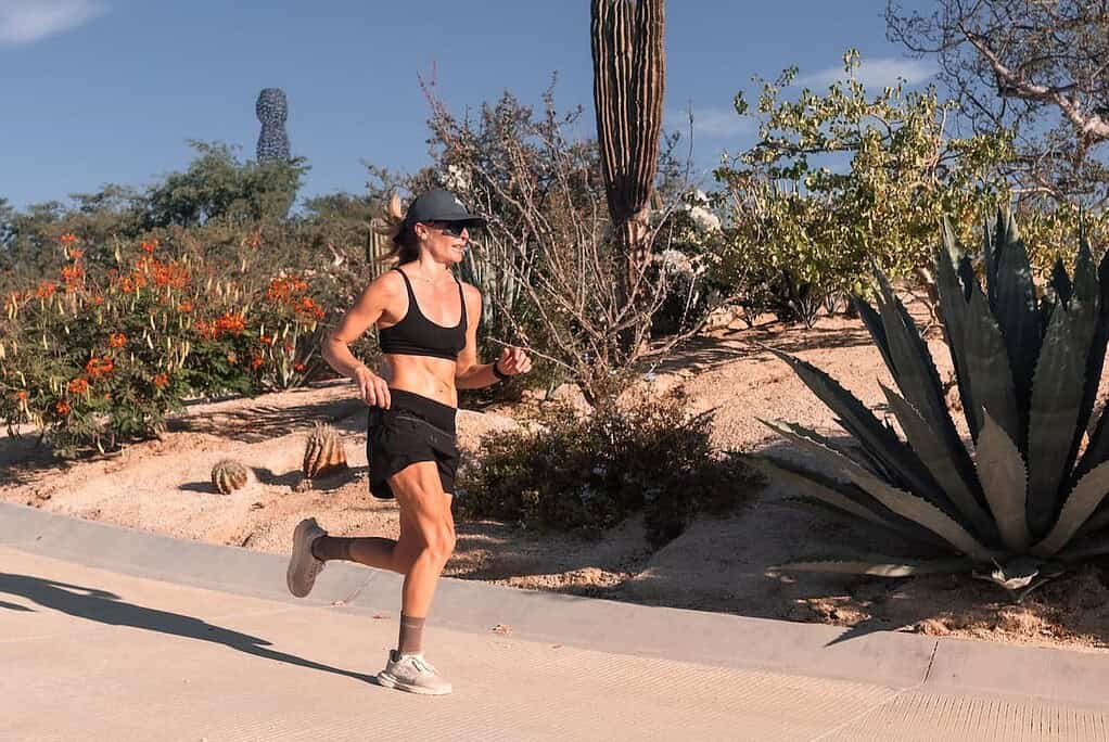 Female athlete running outdoors in a desert landscape, showcasing triathlon training in warm climate conditions. Active lifestyle, endurance, and fitness focus for triathlon enthusiasts and athletes.