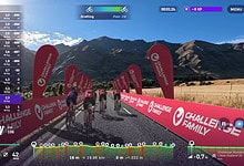 Cycling training simulation for triathlon athletes showcasing mountain scenery and branded challenge family banners in an outdoor triathlon setting.