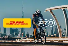 Professional triathlete riding a bike in Dubai with DHL and PTO logos, city skyline in background.
