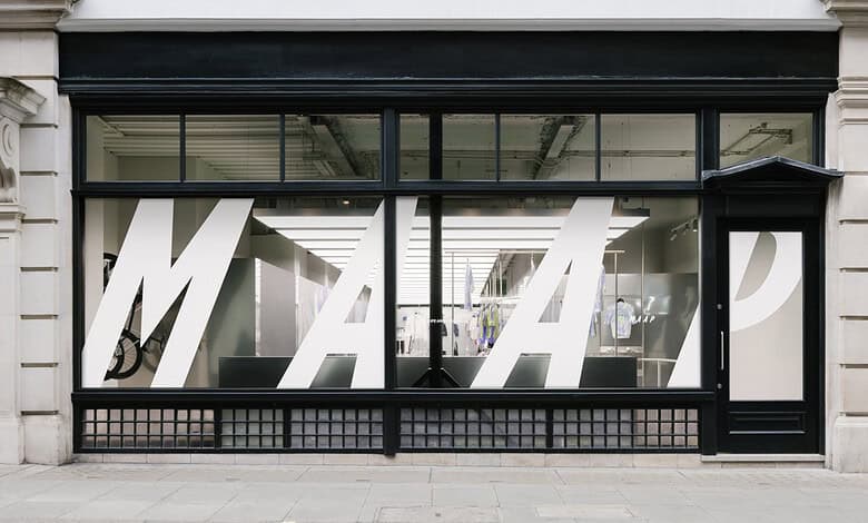 Contemporary office storefront featuring large white M A P letters on glass windows, with a sleek black frame and urban street setting.