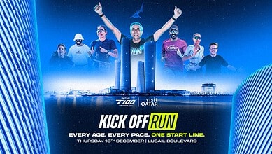Group of diverse runners celebrating at the start line of the Triathlon Insight Kick Off Run event in Lusail, Qatar, with city skyline background.