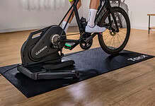 Cyclist riding indoors on a Tacx Nēra smart trainer with a preinstalled cassette.